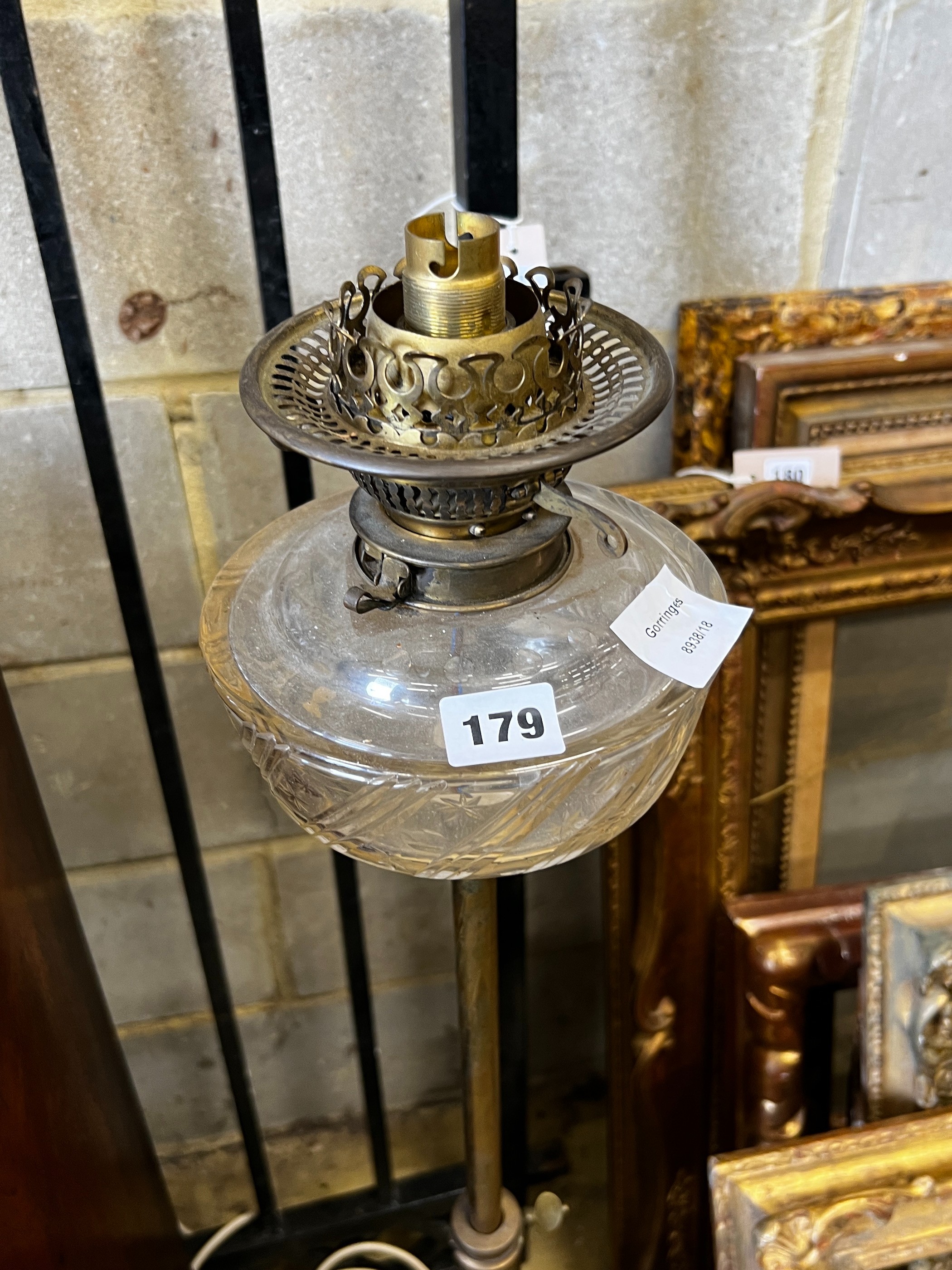 A late Victorian brass oil lamp standard (converted) on associated telescopic cast iron stand, height 112cm